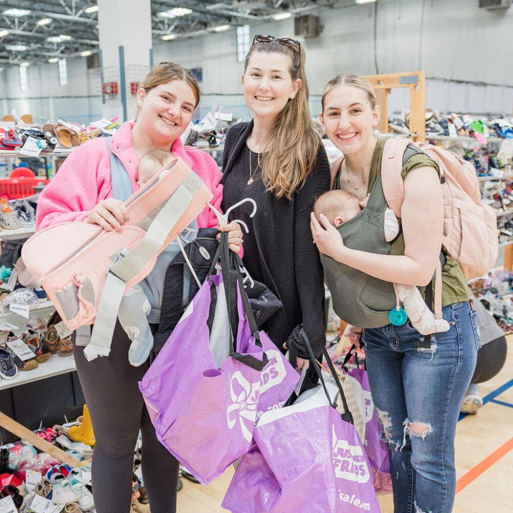 A A group of friends pose together with their shopping finds at a JBF sale in Texas.